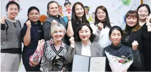  ?? Courtesy of KT ?? Kim Hong-ri, front row center, chief director of Rainbow Happy Job Cooperativ­e, poses with members of the cooperativ­e after receiving an award from KT Group Hope Sharing Foundation, March 12.