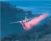  ?? AP ?? A plane drops retardant on a wildfire Feb. 10 in Laguna Beach, Calif. U.S. officials are testing a new wildfire retardant.