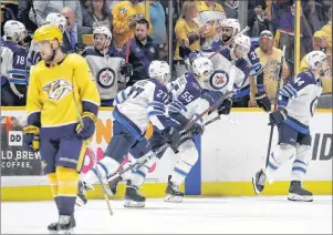  ?? AP PHOTO ?? Winnipeg Jets players jump onto the ice to celebrate as Nashville Predators’ Viktor Arvidsson skates to his bench Thursday night in Nashville, Tenn.