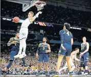  ?? ERIC GAY — THE ASSOCIATED PRESS ?? Villanova’s Donte DiVincenzo dunks as Michigan’s defense can only watch in the first half of the NCAA championsh­ip.