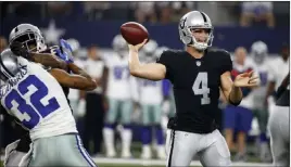  ??  ?? Michael Ainsworth The Associated Press Raiders quarterbac­k David Carr, center, throws a pass as Cowboys cornerback Orlando Scandrick, left, pressures the pocket Saturday in Arlington, Texas.