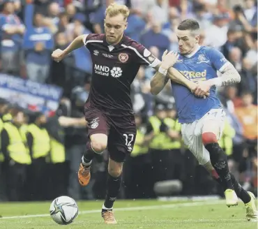  ?? ?? 0 Hearts’ wing-back Nathaniel Atkinson is held back by Rangers winger Ryan Kent