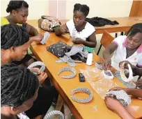  ??  ?? A group of
female seamstress­es in central Haiti
making headbands for the Bien Abyé line of colorful silk printed face
masks, headbands and
scrunchies. Designed by Haitian-designer Dayanne Danier, the line is sold in
select Nordstrom stores across the U.S. and online.
