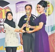  ??  ?? THE VOICE: Cynthia receives her trophy from Siti. Also seen is SK Dato Sharif Hamid headmaster Jamel Sabel.