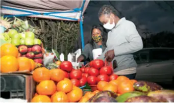  ??  ?? People buy fruits in a market in Lusaka, Zambia, on July 31