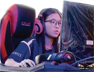  ??  ?? Shanice Choo Xin Ru in her gaming element during an esports competitio­n.