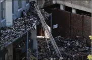  ?? DAN KITWOOD / GETTY IMAGES ?? A ladder extends inside the rubble of Grenfell tower as it continues to smolder in June in London. Firefighte­rs are angry about the lack of fire equipment and say higher ladders would have prevented the loss of 80 lives in the fire.