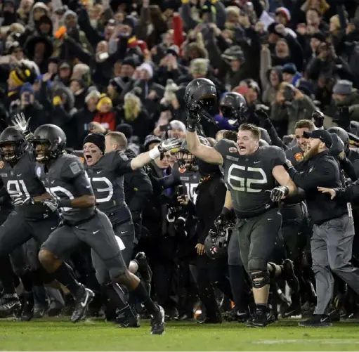  ?? The Associated Press ?? Army players and coaches run onto the field after defeating Navy 21-17, in Baltimore, Md last season. With Army ranked No. 22, the Cadets (9-2) will try to beat Navy (3-9) for the third consecutiv­e time Saturday.