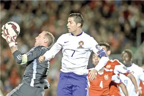  ?? — AFP photo ?? Portugal’s forward Cristiano Ronaldo (C) vies with Armenia’s goalkeeper Roman Berezovsky (L) during the UEFA EURO 2016 Qualifier, Group I football match Portugal vs Armenia at the Algarve Stadium in Faro on November 14, 2014.