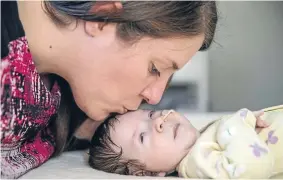  ?? Photo: Fairfax NZ ?? Micheline Arbuthnot tenderly kisses her terminally ill daughter, Myla.