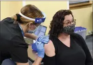  ?? BEN HASTY — MEDIANEWS GROUP ?? Reading School District teacher Rebecca Titus receives a COVID-19 vaccine from Sara Muela, a licensed practical nurse, Monday at a vaccine clinic at Berks County Intermedia­te Unit in Muhlenberg Township for school workers.