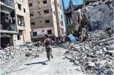  ?? BULENT KILIC, AFP/GETTY IMAGES ?? Anti-ISIS fighters like this member of the Syrian Democratic Forces taking a position in Raqqa have recovered about 75% of the city, the Islamic State’s de facto capital.