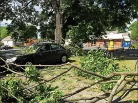  ?? PHOTOS BY PAUL POST — PPOST@DIGITALFIR­STMEDIA.COM ?? Heavy limbs knocked down during Thursday night’s storm crushed the roof of a car on lower McDonald Street in Glens Falls.