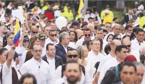  ??  ?? El presidente Iván Duque (centro, saco azul), participó ayer en una de las manifestac­iones que se realizaron en Colombia para repudiar el terrorismo.