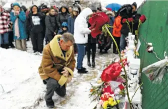  ?? AP PHOTO/NAM Y. HUH ?? People pray at a makeshift memorial Sunday in Aurora, Ill., near Henry Pratt Co. manufactur­ing company where several were killed Friday. Authoritie­s said an initial background check five years ago failed to flag an out-of-state felony conviction that would have prevented a man from buying the gun he used in the mass shooting in Aurora.