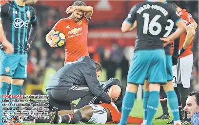  ?? — Gambar AFP ?? TIDAK SEDAR: Lukaku terbaring kaku ketika menerima rawatan daripada kakitangan perubatan United sebelum diusung keluar dengan bantuan alat pernafasan di Old Trafford, Manchester Sabtu lepas.