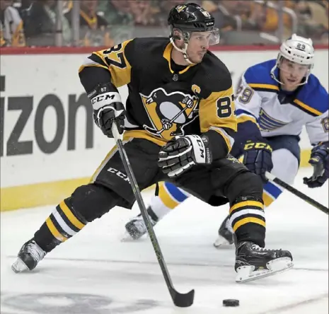  ?? Associated Press photos ?? Sidney Crosby looks to get off a backhander as he maneuvers around the St. Louis net while being defended by the Blues’ Vince Dunn Saturday at PPG Paints Arena.