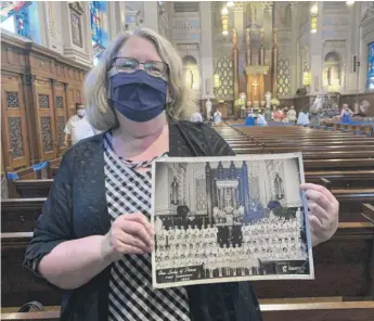  ?? TOM SCHUBA/SUN-TIMES PHOTOS ?? Eileen Langan displays her first communion photo at Our Lady of Peace. “It’ll always be my home church. That’s the way I think of it,” she said.