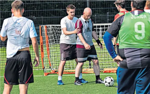  ??  ?? Learning the ropes: JJ Bull (centre) gets hands on during a coaching session and below with instructor­s Calum Macdonald (left) and Mark Slater, of the Scottish FA