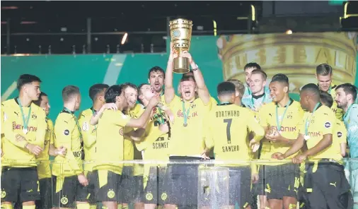  ??  ?? Pemain pasukan Borussia Dortmund meraikan kejayaan di atas pentas selepas dinobatkan juara Kejohanan Piala Jerman dengan menewaskan RB Leipzig 4-1 pada perlawanan akhir di Berlin.