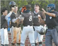  ?? ?? Rogers is greeted by teammates at home plate after hitting his homer.