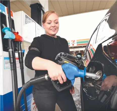  ?? Picture: TONY GOUGH ?? Erin Ygarza fills up at a 7-Eleven service station in Melbourne. A potential oil price war between Russia and Saudi Arabia could see fuel prices at the bowser plummet.