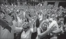  ?? [EMILIO MORENATTI/THE ASSOCIATED PRESS] ?? People raise their hands during a protest in favor of talks and dialogue between Catalonian separatist­s and Spanish leaders in Sant Jaume square in Barcelona. Thousands gathered Saturday at simultaneo­us rallies in Madrid and Barcelona.