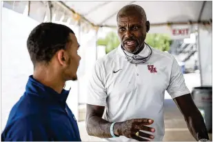  ?? TAMIR KALIFA / AMERICAN-STATESMAN ?? Carl Lewis, a 10-time Olympic gold medalist and now an assistant coach at Houston, counsels Nick Alexander, who will compete for the Cougars next year.