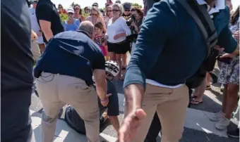  ?? AP PHOTO/MANUEL BALCE CENETA, ?? President Joe Biden is helped by U.S. Secret Service agents after he fell trying to get off his bike to greet a crowd on a trail June 18 at Gordons Pond in Rehoboth Beach, Del. On Friday, the Associated Press reported on stories circulatin­g online incorrectl­y claiming the Atlantic published an article with the headline, “The Heroism of Biden’s Bike Fall” after Biden fell as he tried to dismount his bicycle.