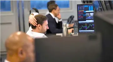  ??  ?? Dealers work at their desks whilst screens show market data following a vote by Prime Minister May’s Brexit ‘plan B’ at CMC Markets in London, Britain. With just 40 days until the UK is due to leave the EU, businesses are testing their emergency Brexit preparatio­ns to ensure they have enough cash and staff in the event of a disorderly exit. — Reuters photo