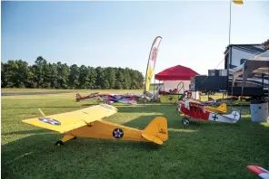  ?? Staff photo by Kelsi Brinkmeyer ?? ■ Remote control planes wait to be flown at the Texarkana Radio Control Flying Club annual fly-in on Friday evening at Wright Patman Lake. The event will take place all weekend.