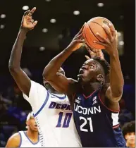  ?? Charles Rex Arbogast / Associated Press ?? UConn’s Adama Sanogo (21) looks to the basket as DePaul’s Yor Anei defends during a game last season in Chicago.