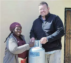  ?? ANNELI HANSTEIN Picture: ?? HELP THAT MATTERS: Marius Visser, owner of LP Gaz Port Alfred, hands a 9kg cylinder of gas to Gertrude Sigonyela on Tuesday 13 September 2022. Visser has pledged to donate 9kg of gas every month for the next two years to support the soup kitchen that Sigonyela runs from her Nemato home.