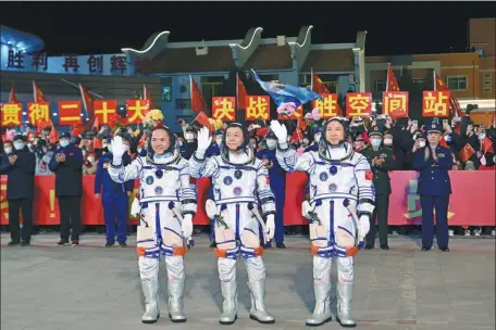  ?? WANG JIANGBO / FOR CHINA DAILY ?? Crew members of the Shenzhou XV space mission — Major General Fei Junlong (right), Senior Colonel Deng Qingming (center) and Senior Colonel Zhang Lu — wave during a ceremony on Tuesday night prior to their departure from Jiuquan Satellite Launch Center in Northwest China.