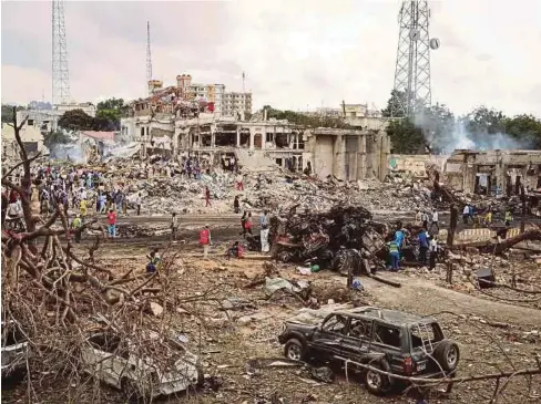  ??  ?? KEADAAN lokasi serangan bom trak di satu persimpang­an berhampira­n sebuah hotel di tengah Mogadishu kelmarin. - AFP