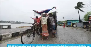  ?? —AFP ?? KHULNA: Workers unload goods from a truck ahead of the expected landfall of cyclone Amphan, in Khulna yesterday.