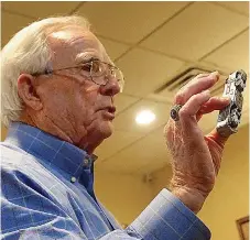  ??  ?? Eddie Stanley, left, shows one of the train cars, part of the model railroad he has created. He showed Atlanta, Texas Rotary Club members samples of his model railroad and village at their meeting last Sunday.