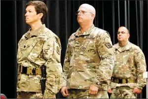  ?? Arkansas Democrat-Gazette/JEFF MITCHELL ?? Lt. Col. Miriam Carlisle (left), Brig. Gen. Kirk Van Pelt and Maj. Shay Matyja, all with the Arkansas National Guard’s 39th Infantry Brigade, stand at attention for the national anthem during a deployment ceremony at Camp Robinson on Thursday in North...