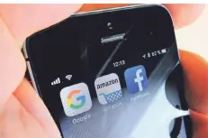  ?? FOTO: STEFAN JAITNER/DPA ?? Die Logos der Us-internetko­nzerne Google, Amazon und Facebook sind auf dem Display eines iphones von Apple zu sehen.