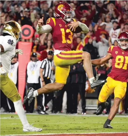  ?? AP ?? USC quarterbac­k Caleb Williams jumps in for a touchdown during the second quarter. He ran for three TDs and passed for one.