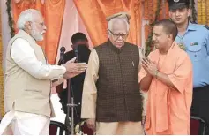  ??  ?? Prime Minister Narendra Modi congratula­tes newly sworn-in Uttar Pradesh Chief Minister Yogi Adityanath as Governor Ram Naik looks on, at the oath ceremony in Lucknow on Sunday