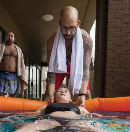  ?? PETER POWER FOR THE TORONTO STAR ?? Giovanni Bartolomeo encourages Ashley Trevisani of Hamilton as she reclines in a 4 C ice bath during a Wim Hof Method workshop in April.