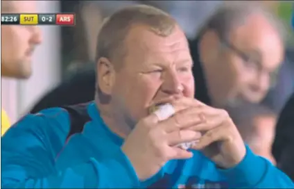  ??  ?? El portero suplente del Sutton, Wayne Shaw, de 45 años, comiéndose un bocadillo en el banquillo durante el partido contra el Arsenal
