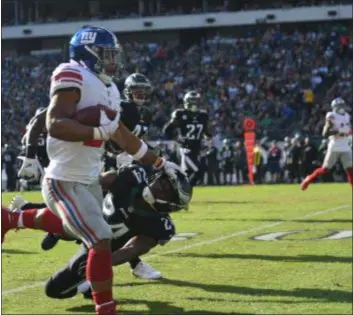  ?? MICHAEL REEVES – FOR DIGITAL FIRST MEDIA ?? Giants running back Saquon Barkley gives Eagles safety Corey Graham a stiff-arm during one of Barkley’s rare plays in the second half Sunday.
