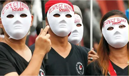 ?? AP FOTO ?? FACING THE ISSUE. Protesters wearing masks with messages pushing for human rights took to the streets in Manila on Sunday, Human Rights Day.