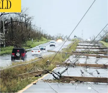  ?? RICARDO ARDUENGO / AFP / GETTY IMAGES ?? Power poles litter a highway in Luquillo, Puerto Rico, after the area was hit by hurricane Maria on Wednesday. No deaths have yet been reported in the U.S. territory, despite widespread flooding and winds of up to 250 km/h.