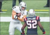  ?? ADAM GLANZMAN — GETTY IMAGES ?? Foster Moreau of the Raiders scores a touchdown during the second quarter against the New England Patriots at Gillette Stadium on Sunday.