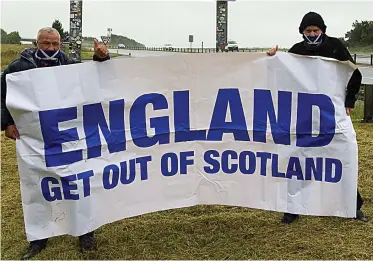  ??  ?? Stay away: Two protesters make their feelings known to motorists near Berwick