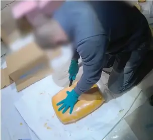  ?? ?? Officers cut open blocks of Gouda cheese to reveal packages of cocaine hidden inside