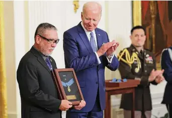  ?? Photos by Win Mcnamee/getty Images ?? John Kaneshiro accepts a posthumous Medal of Honor for his late father, Army Staff Sgt. Edward Kaneshiro, who helped three squads of men escape after an ambush in Vietnam.